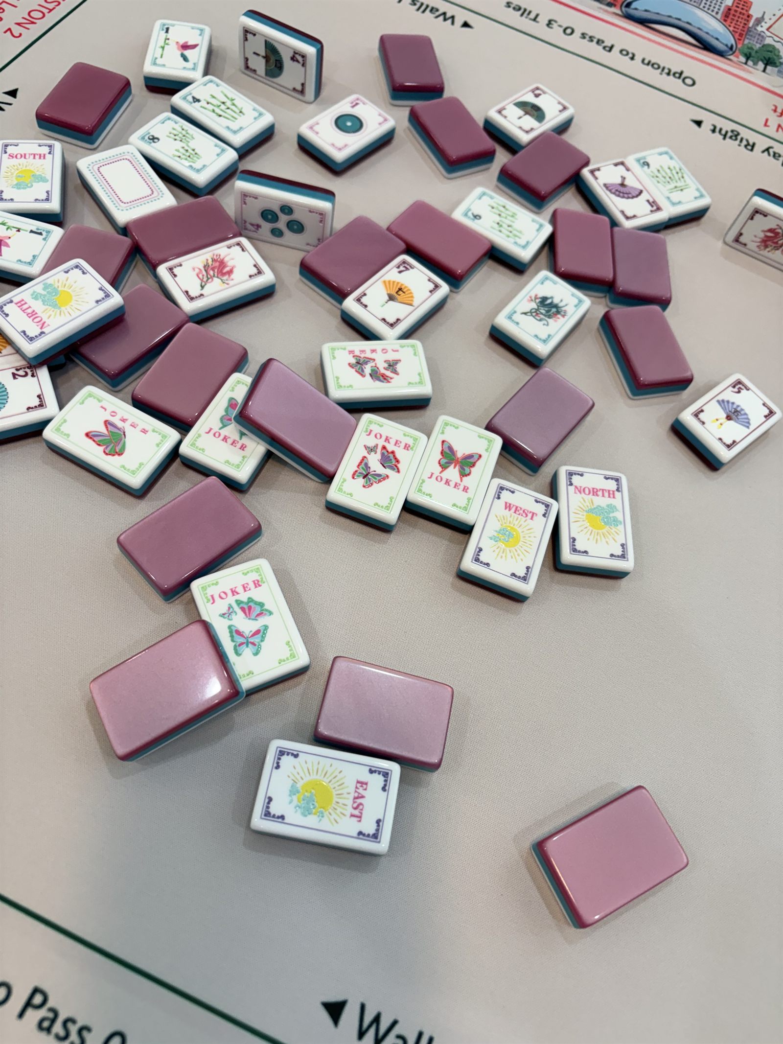 Mauve and white tiles with butterfly jokers scattered on a blush mat