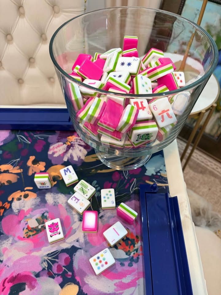 Hot pink and lime striped tiles in a glass bowl on a navy floral mat with cobalt racks