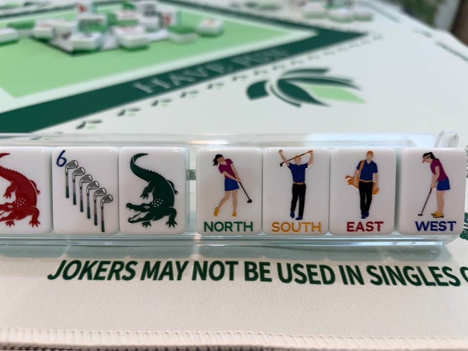 White tiles with golfers, golf clubs, and alligators in a rack on a green and white mat