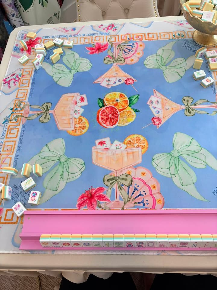 Periwinkle mat with watercolor martini glasses, citrus, and bows, with butter-yellow layered tiles and a pink rack